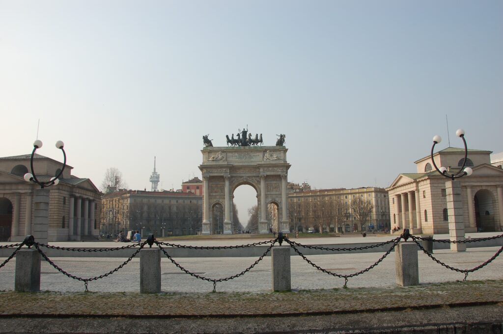 Arco della Pace, Milánó klasszicista diadalíve a Parco Sempione bejáratánál és Tavaszi virágokkal színesített parkösvény a Parco Sempione területén és Castello Sforzesco előtti szökőkút Milánóban, turistákkal körülvéve, valamint Monumentális temető Milánóban, művészi síremlékek és márvány szobrok között