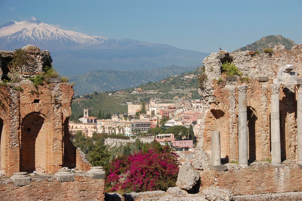 Napsütötte Taormina régi romokkal háttérben az Etna vulkán havas csúcsa
