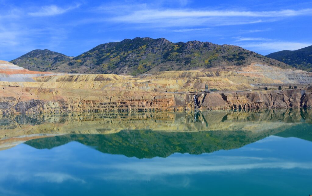 A Berkeley Pit elárasztott, mély bányagödre Montanában, vörösesbarna sziklafalakkal és élénk, állóvízzel