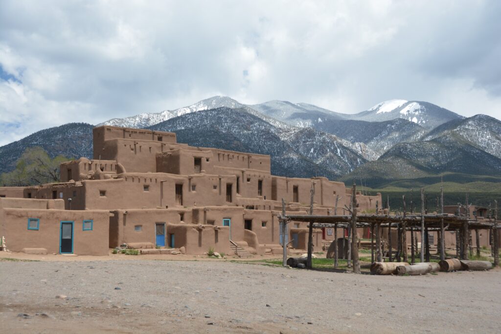 Taos, Új-Mexikó városának látképe, a festői hegyekkel körülvéve és a hagyományos adobe épületek sziluettjével